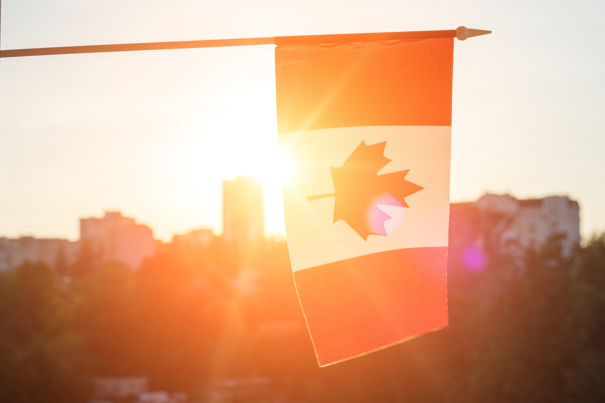 Drapeau du Canada depuis la fenêtre sur fond de coucher de soleil